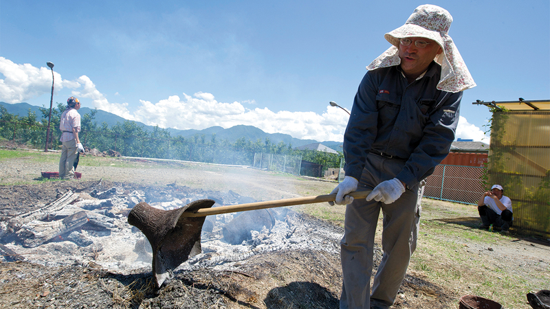 عالم آثار ياباني يزيح برفق إحدى القطع الفخارية التي تعود لعهد حضارة الجومون.  إي.بي.إيه