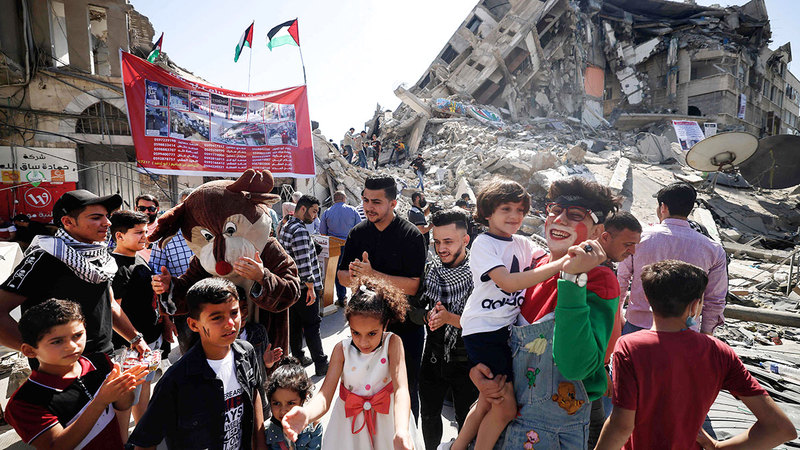 أطفال فلسطينيون يلعبون إلى جانب بيوتهم التي دُمّرت خلال الصراع الأخير بين «حماس» وإسرائيل في مايو الماضي.  أ.ف.ب