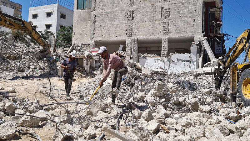 عمال خلال البحث عن حديد التسليح بين الركام.    الإمارات اليوم