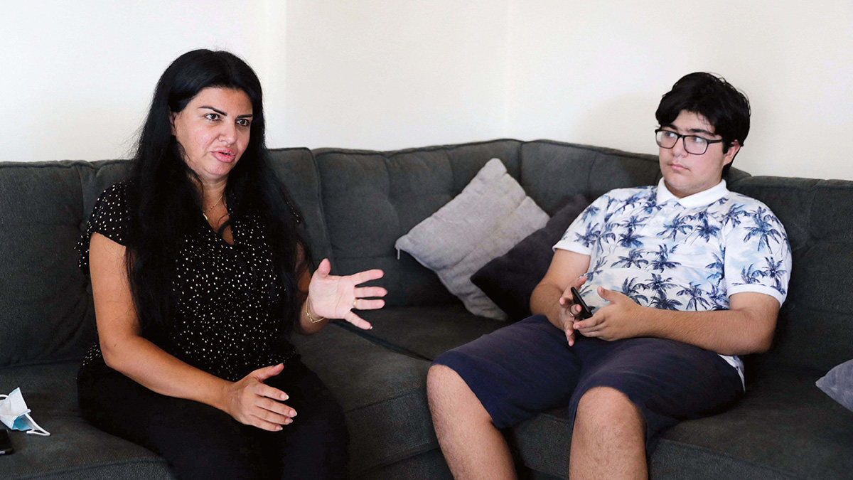 رولا مراد برفقة ابنها «ريان» الذي تنوي إلحاقه بمدرسة حكومية مثل أخيه بعد تراجع إمكانات العائلة. . أ.ف.ب