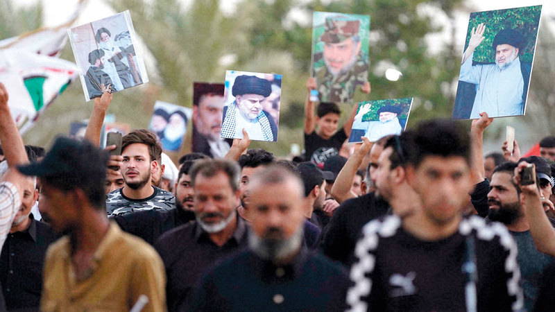 أنصار مقتدى الصدر يحملون صوره في النجف.   من المصدر