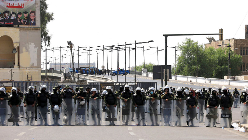 قوات مكافحة الشغب تغلق طريقاً رئيساً في العاصمة بغداد.   إي.بي.إيه