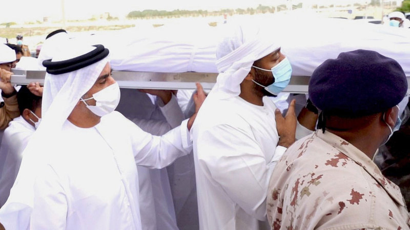 سيف بن زايد خلال مشاركته في تشييع جثمان شهيد الواجب خميس الهولي.   وام