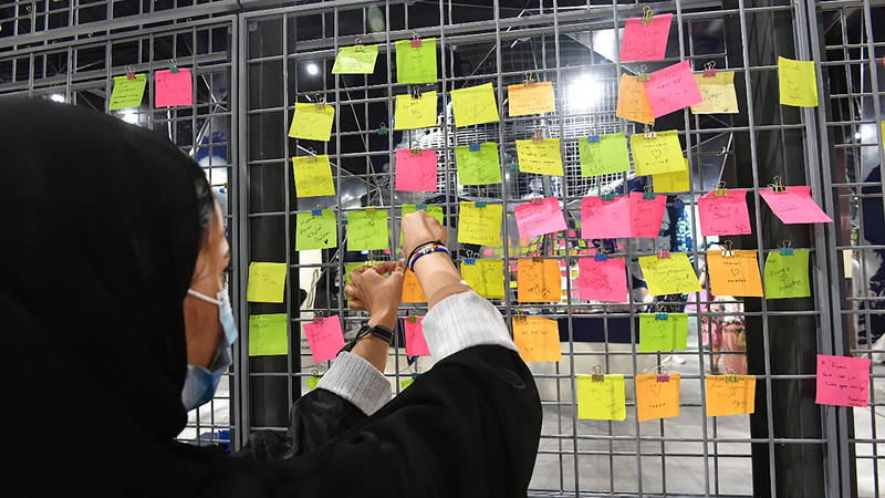 زائرة تضع أمنيتها على المنصة.  تصوير: مصطفى قاسمي