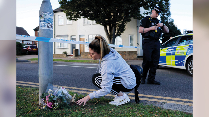 فتاة تضع باقة من الزهور في الموضع الذي قُتل فيه النائب أميس.  أ.ب