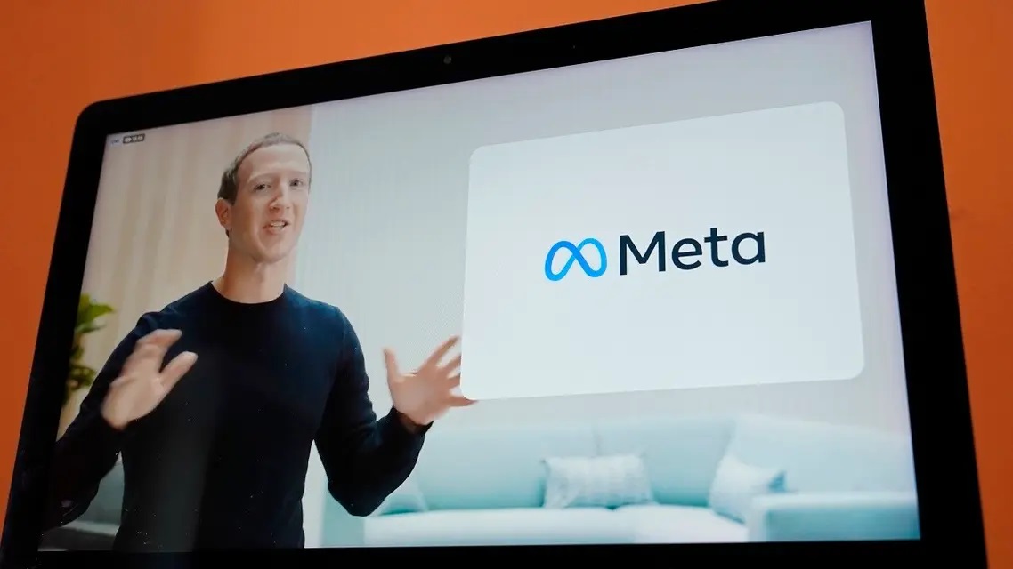 مارك زاكربرغ بجانب الشعار الجديد لشركة ميتا (فيس بوك سابقا)