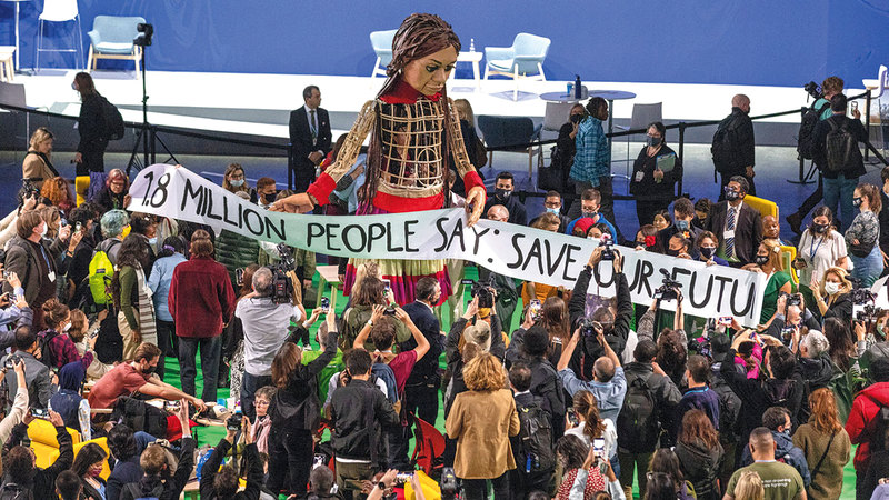 مشاركون في قمة المناخ يستقبلون «أمل» خارج قاعة الاجتماعات.   أ.ف.ب