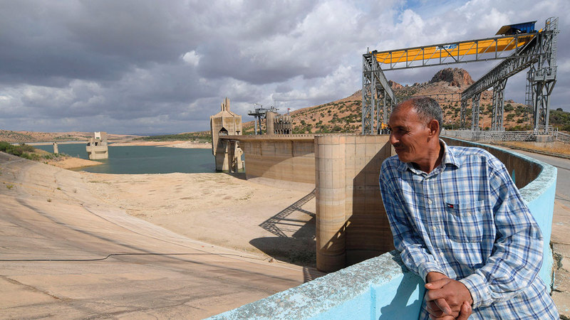 أحد العاملين في السد ينظر إلى المياه المنحسرة بحسرة شديدة. 	  أ.ف.ب