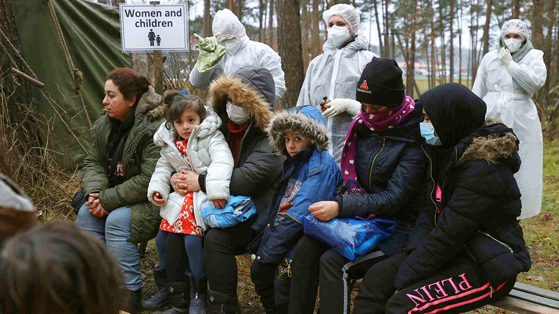 مجموعة من المهاجرين ينتظرون عرضهم على الطبيب بعد إصابتهم بالمرض جراء البرد بسبب إقامتهم في العراء.   أ.ب
