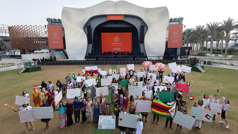 مشاركون في الاحتفالية حملوا لافتات بلغات بلدانهم مكتوباً عليها «كلمة شكر» لدولة الإمارات.  تصوير: أحمد عرديتي