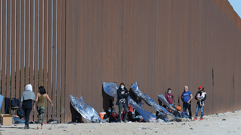 مهاجرون دخلوا الولايات المتحدة بعد قطع نهر كولورادو من المكسيك في انتظار المساعدة لتسوية أوضاعهم.   أ.ب
