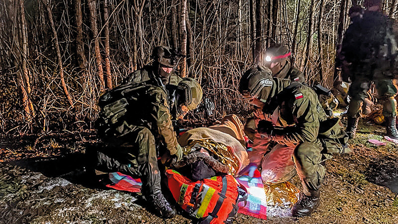 صورة وزّعها حرس الحدود البولندي لعملية إنقاذ أحد المهاجرين الـ 4.    رويترز