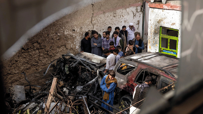 أقارب وجيران عائلة أفغانية قُصفت وقُتل 10 من أفرادها عن طريق الخطأ يعاينون الدمار الذي حل بالمكان.    عن «نيويورك تايمز»