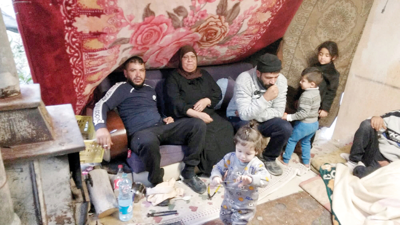 منذر وجواد نصار ووالدتهما داخل خيمة التشرد.   الإمارات اليوم