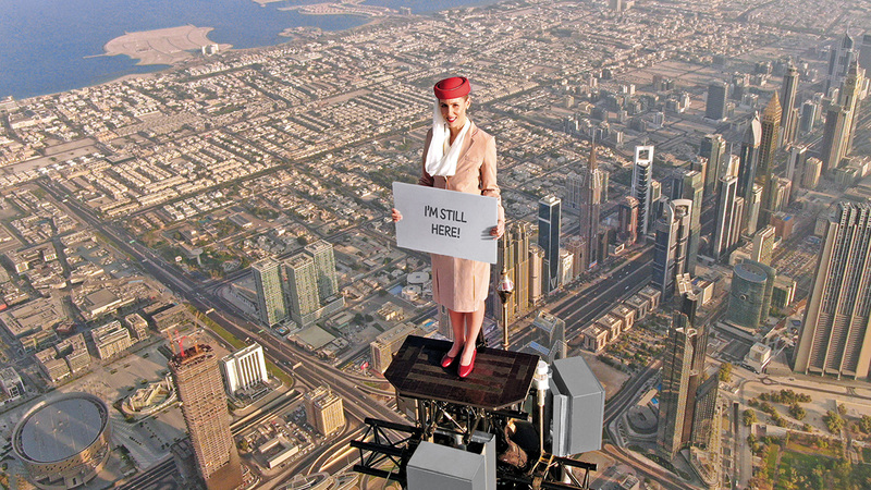 «المرأة الجريئة» على قمة برج خليفة وهي تحمل لوحات الرسائل مع دعوة لزيارة «إكسبو».   من المصدر