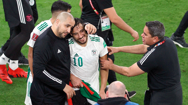 بوقرة خلال الاحتفال مع اللاعب الجزائري يوسف بلايلي خلال الفوز بكأس العرب الأخيرة.   من المصدر