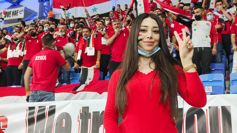 مشجعة سورية ومن خلفها أعداد كبيرة من عشاق الكرة السورية.	  تصوير: أسامة أبوغانم
