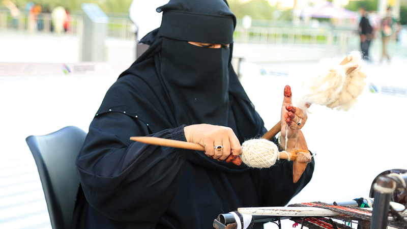 «أم فهد» تنسج أحزمة نسائية وقطعاً فنية صغيرة الحجم مخصصّة لعمليات تزيين المنزل.	من المصدر