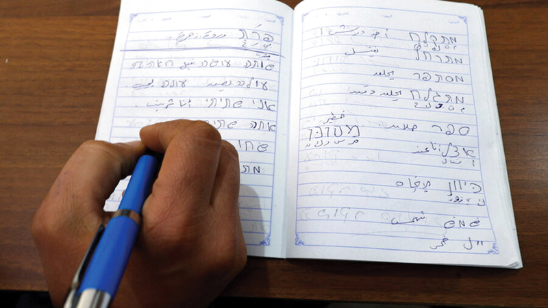 طالب في مركز «رفها» يكتب بالعبرية خلال حضوره أحد الدروس. 	  من المصدر