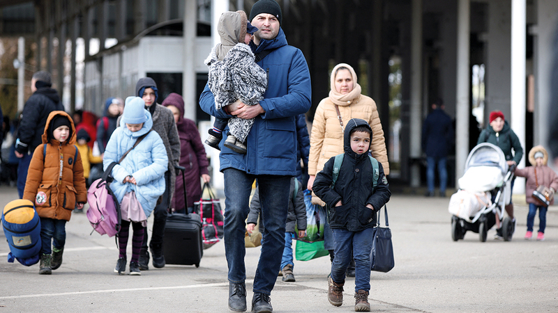 أب مع عائلته في إحدى حالات التشرّد الكثيرة الناجمة عن الأزمة الأوكرانية.   رويترز