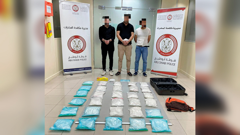 أفراد العصابة وأمامهم جانب من المضبوطات.   من المصدر