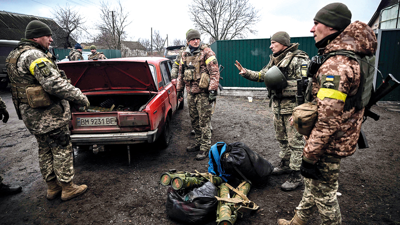 جنود أوكرانيون يفرغون أسلحتهم من سيارة قديمة استعداداً للتحرك إلى موقع متقدم.   أ.ف.ب