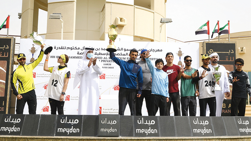 الأبطال يحتفلون على منصّة التتويج.   تصوير: أسامة أبوغانم