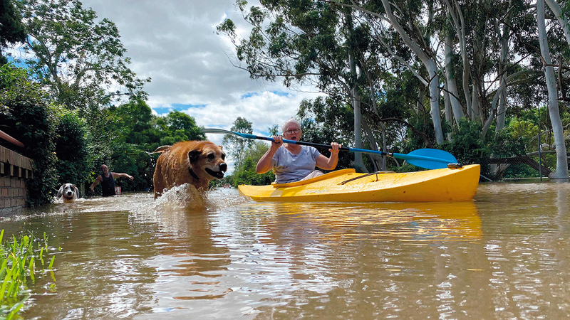 السكان يتحركون بالقوارب في شوارع غمرتها المياه.   أ.ف.ب