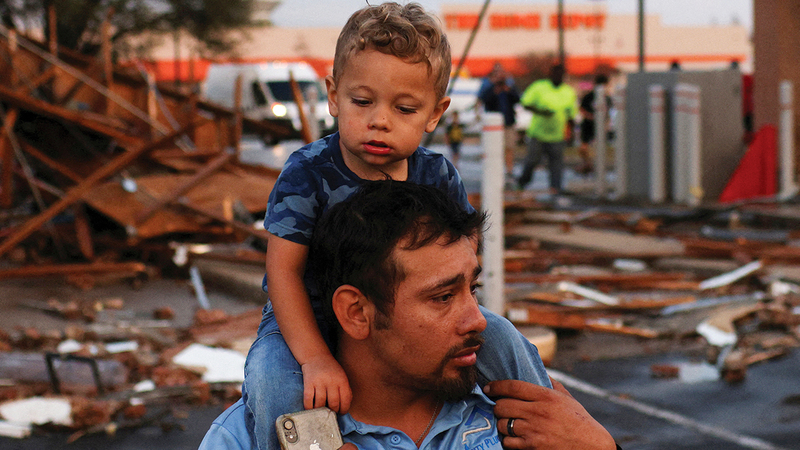 أب وابنه يهربان من الكارثة.   أ.ب