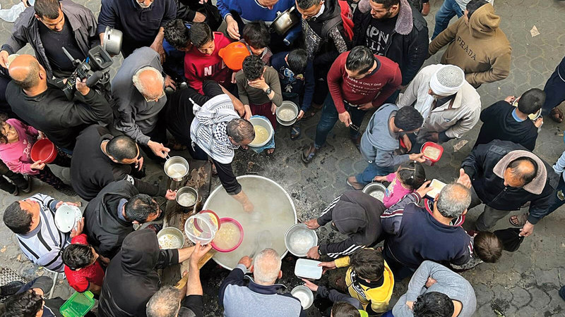 الحطاب يطهو «الجريشة» ويقدمها للفقراء أمام منزله.  الإمارات اليوم