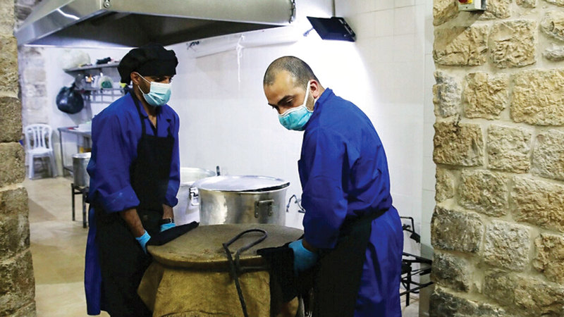 موظفان من أوقاف القدس خلال إعداد الطعام في التكية.   أرشيفية