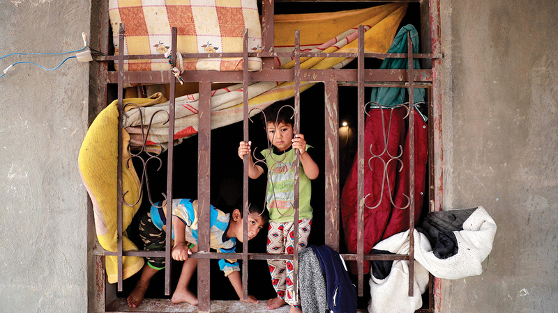 أطفال يلعبون وسط بيوت مدمّرة في قرية حبش.    أ.ف.ب