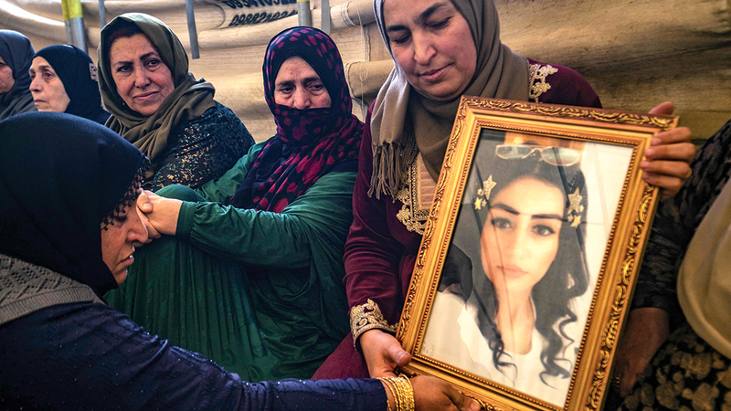 هيام سعدون تحمل صورة ابنتها إيناس عبدالسلام غير مصدقة ما حدث لها.     أ.ف.ب