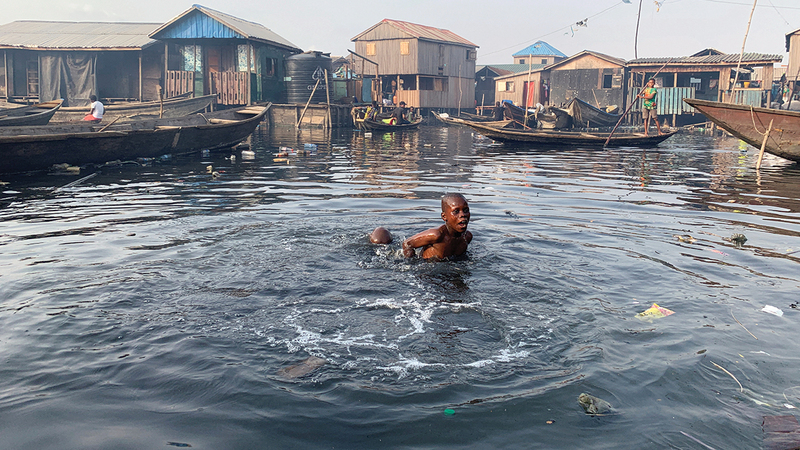 صبي يسبح في مياه ملوثة في لاغوس بنيجيريا.   أ.ب