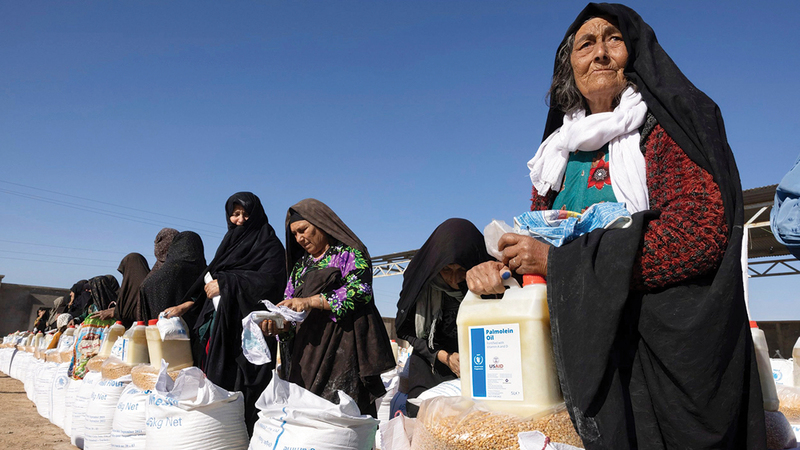 نساء أفغانيات يتسلمن مساعدات من برنامج الغذاء العالمي. أرشيفية