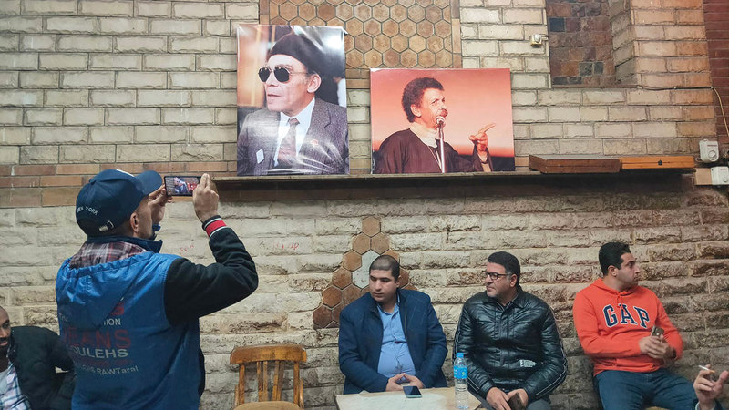 صورة على جدار للشيخ إمام (يسار) وأخرى للشاعر أحمد فؤاد نجم. أرشيفية