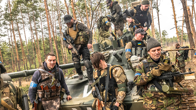 جنود أوكرانيون ومرتزقة يحيطون بدبابة روسية مدمرة. من المصدر