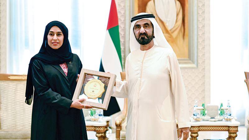 محمد بن راشد يسلم حصة بوحميد تكريم وزارة تنمية المجتمع عن فئة أفضل مبادرة. وام