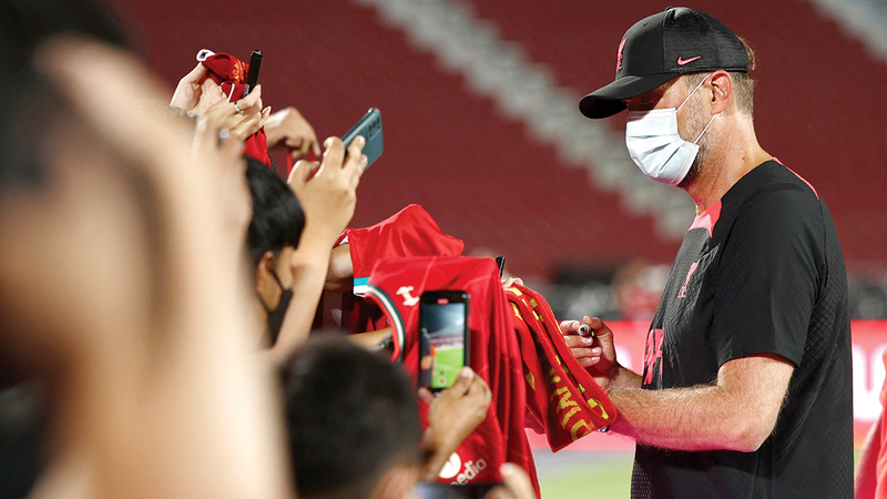 الألماني يورغن كلوب مدرب ليفربول يوقع لمعجبيه في تايلاند خلال تدريبات «الريدز» الخاصة بمواجهة مانشستر يونايتد اليوم على كأس تايلاند. أ.ف.ب