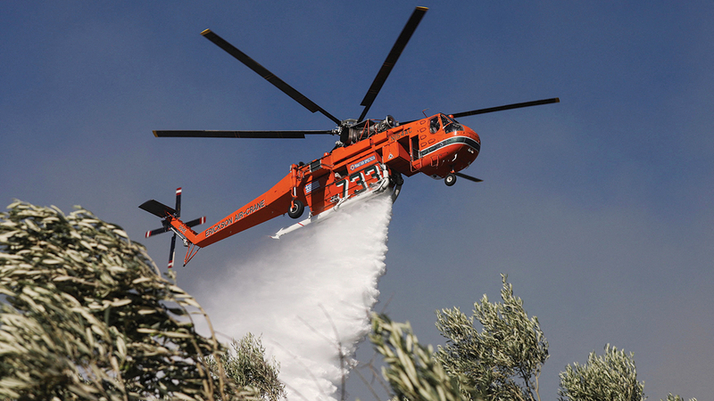 طائرات عمودية تشارك في إخماد النيران التي امتدت بسبب سرعة الرياح.  رويترز