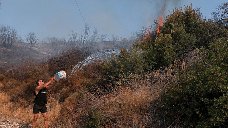 سكان محليون يحاولون إطفاء نيران الغابة في اليونان. رويترز