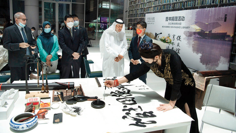 لي دونغشيا رئيسة جمعية الخطاطين الصينيين العالمية ظهرت في الورشة بملابسها الصينية التقليدية.    وام