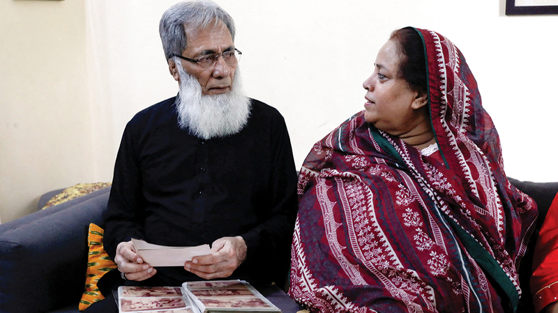 زوجان باكستانيان يتصفحان ألبوم صور عائلية تضم أفراداً من عائلتهما لايزالون في الهند.   رويترز