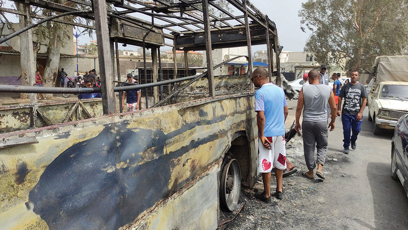 أشخاص يتفقدون سيارة محترقة بعد حريق هائل في القلعة بولاية الطارف شمال شرق الجزائر.    إي.بي.إيه