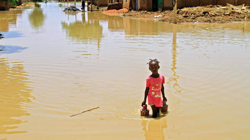طفلة وسط مياه الفيضانات. أ.ف.ب