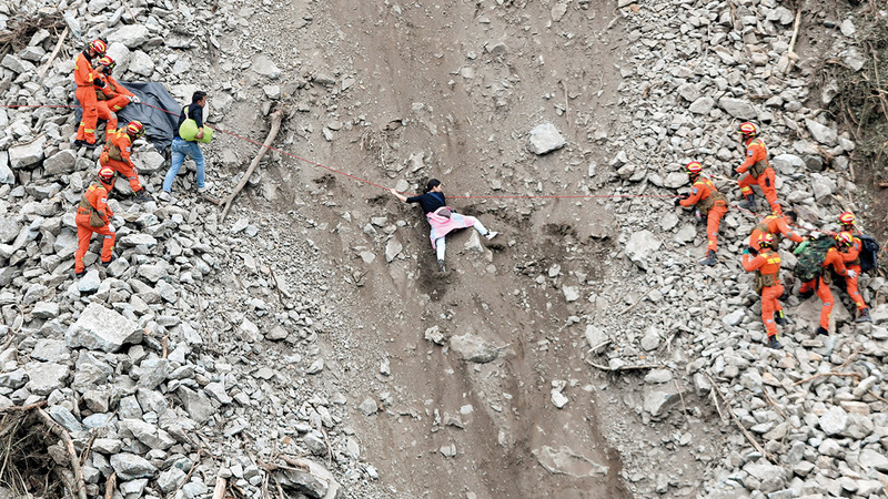 عمال إنقاذ ينتشلون الضحايا من مناطق الانزلاقات الأرضية التي سببها الزلزال. رويترز