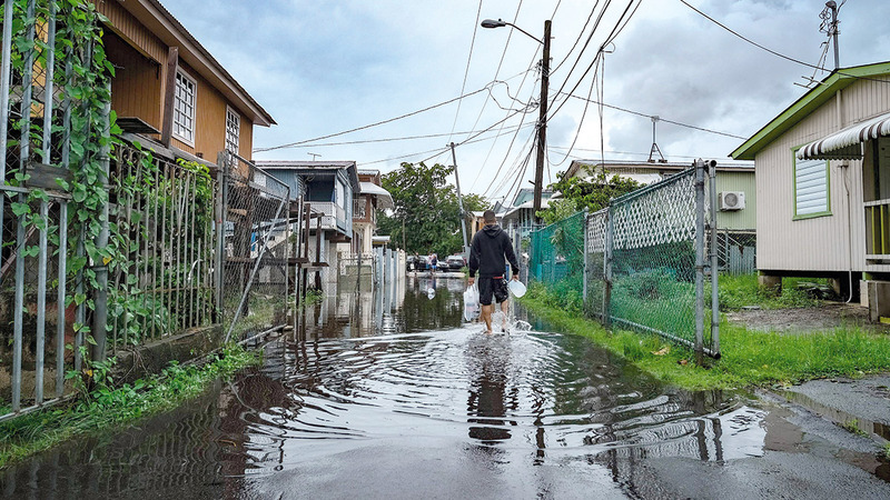 رجل يقطع الشارع وقد غمرته المياه في جمهورية الدومينيكان. أ.ف.ب