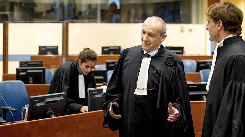 أحد محامي كابوغا يتحدث إلى المدعي العام للمحكمة.   أ.ف.ب