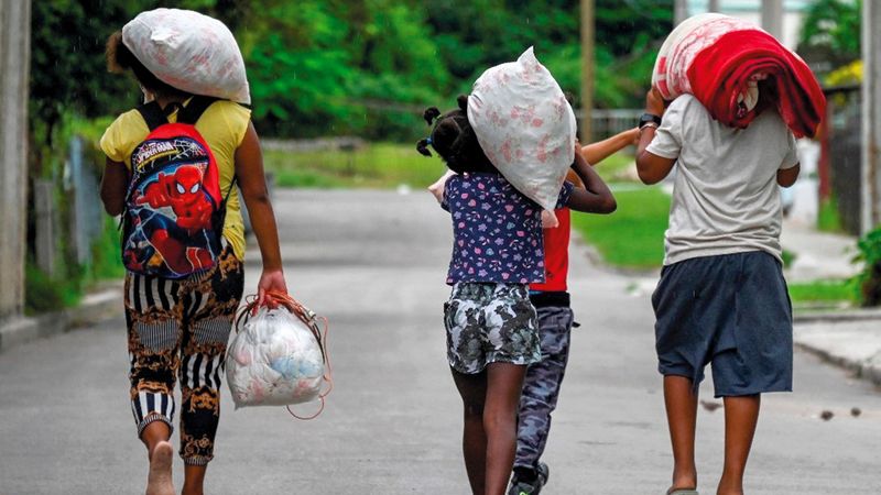 عائلة كوبية رحلت عن بيتها بعد أن دهمها الإعصار. أ.ف.ب