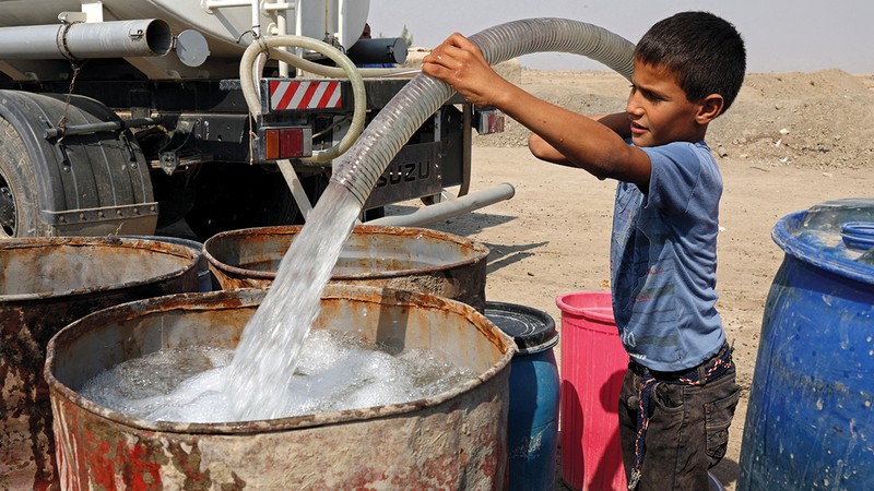 طفل يملأ البراميل من مياه الشرب التي تنقلها مركبات خاصة بعد انقطاع مياه الأمطار وجفاف الأنهار.    رويترز